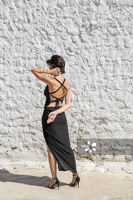 女子靠墙站立，背影图片素材