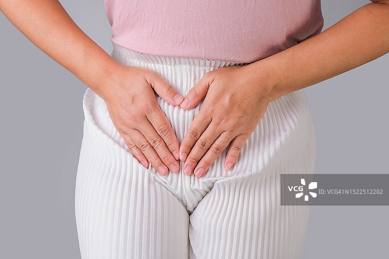 灰色背景中手扶腹部的女子图片素材