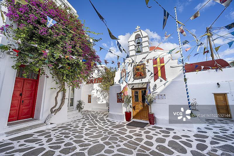 希腊基克拉泽斯群岛米科诺斯岛米科诺斯镇，用旗帜装饰的基克拉泽斯希腊东正教教堂，老城区小巷图片素材