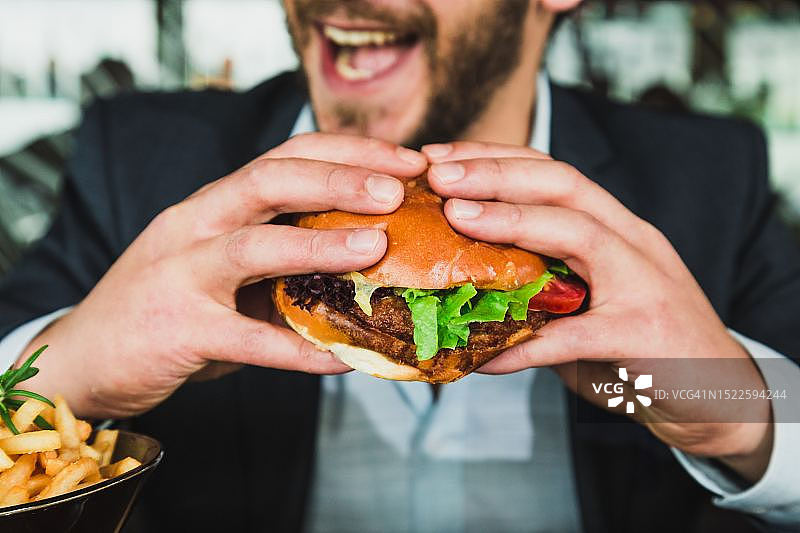 男人拿着汉堡的腰部特写图片素材