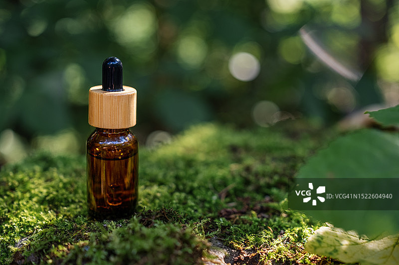 琥珀色滴管瓶，用于精油或精华液，天然材料的环保化妆品包装理念图片素材