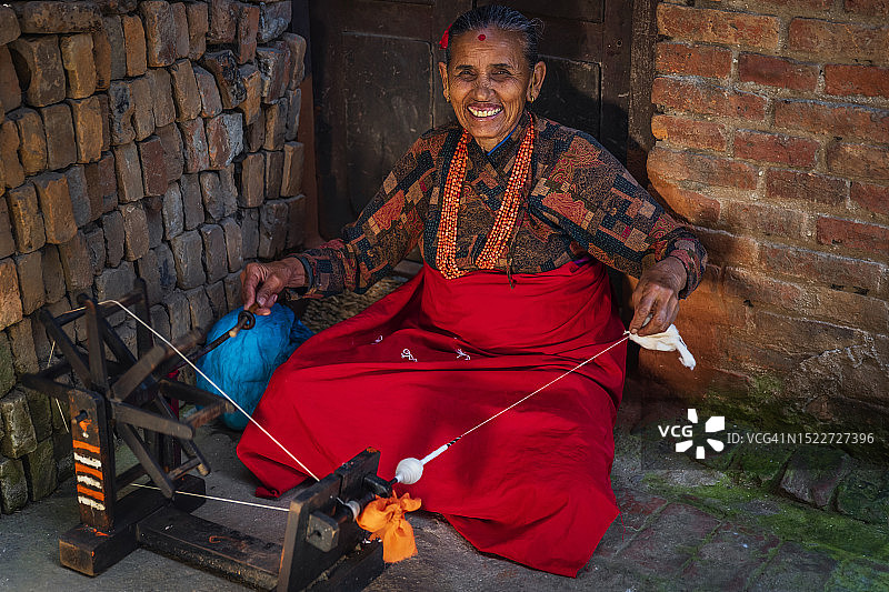 尼泊尔妇女在尼泊尔巴克塔普尔古镇纺羊毛图片素材