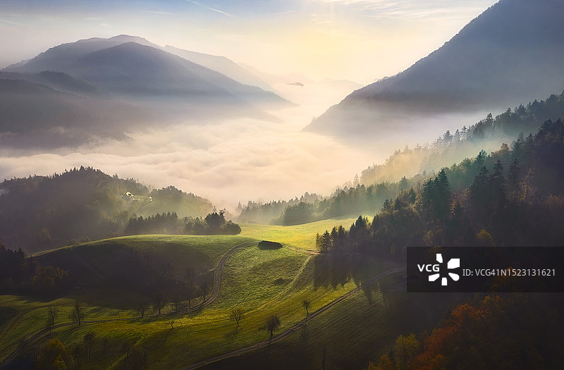 山地景观：丘陵、低云与绿色田野图片素材