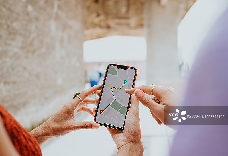 两名妇女在智能手机上使用地图应用程序图片素材