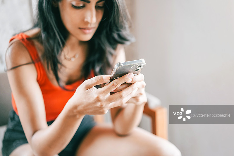 年轻漂亮的亚洲女子用手机发短信图片素材