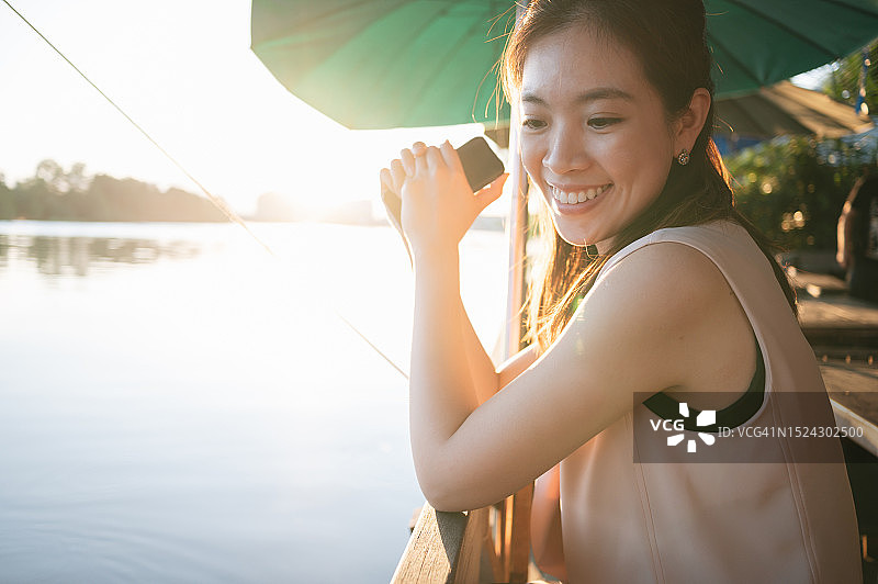 在河边放松的亚洲女商人享受夜晚图片素材