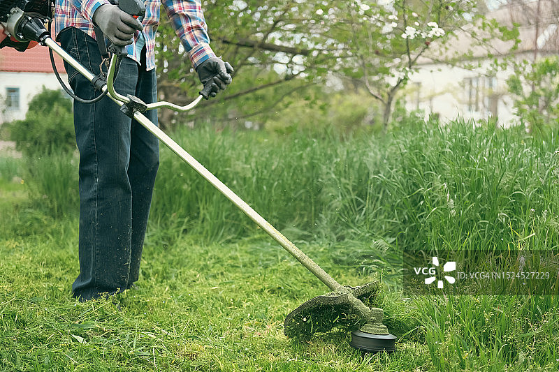 男人在户外使用割灌机工作图片素材