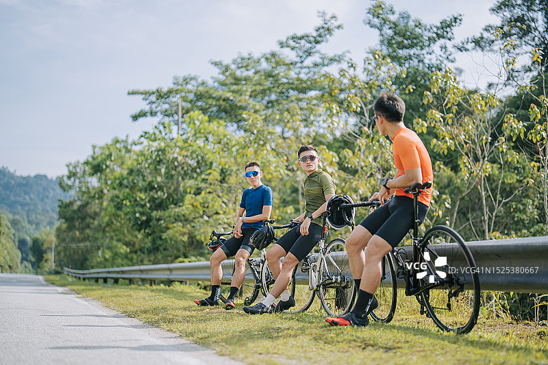 3位骑公路自行车的亚洲男人在乡村早晨休息交谈图片素材