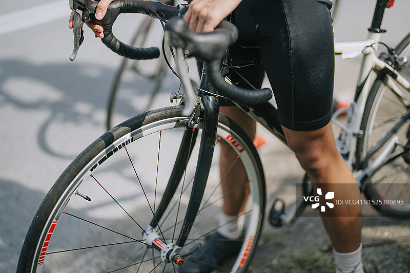周末清晨路边准备的华裔骑行者特写图片素材
