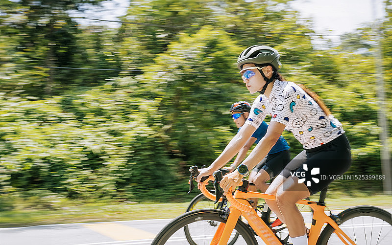 中国亚洲女自行车手在乡村自行车赛中领先图片素材