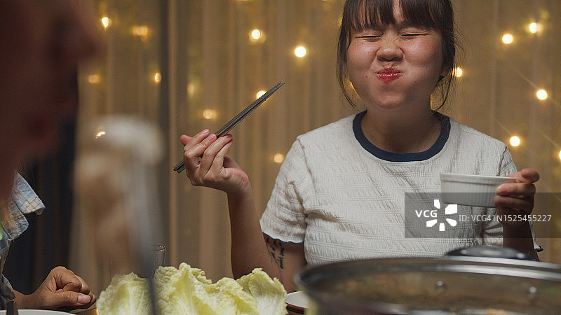 一群快乐的亚洲朋友在家聚餐，吃火锅迎接中国新年图片素材