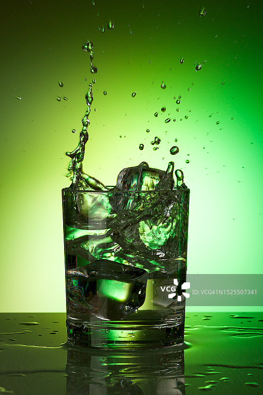 绿色背景下的玻璃杯饮料特写图片素材