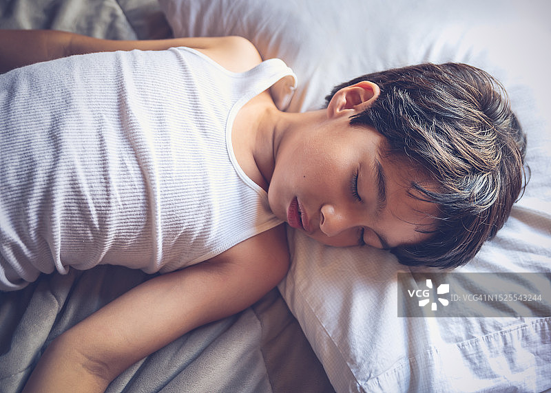 男孩在家里的床上睡觉图片素材
