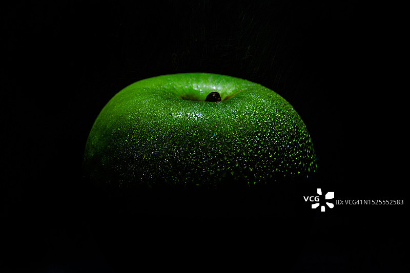 在南非比勒陀利亚黑色背景下的青苹果特写图片素材