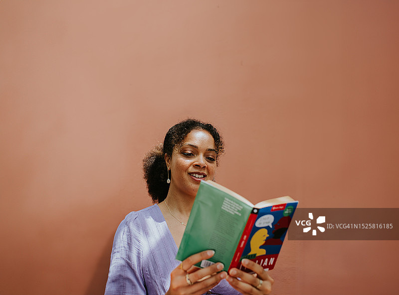 女人在纯色背景下读书，留有文案空间图片素材