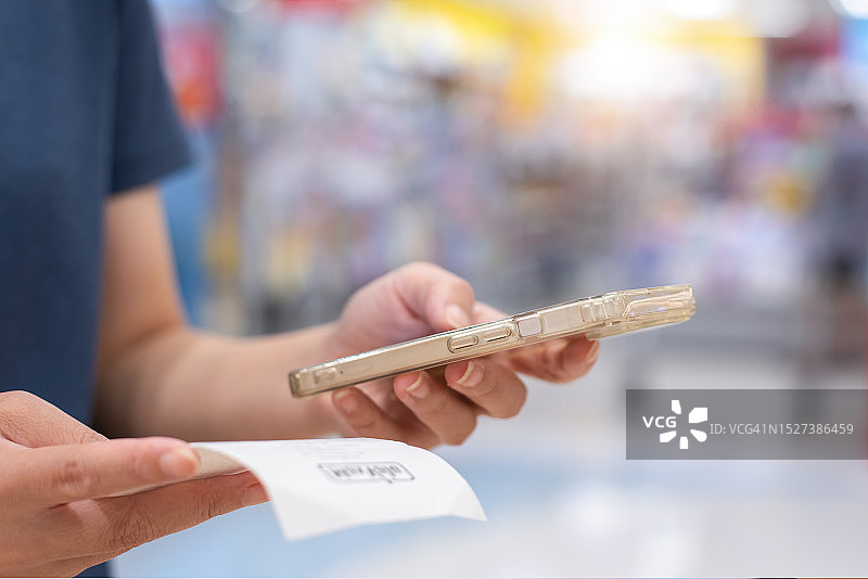 女人使用智能手机扫描账单上的二维码进行在线支付，会计图片素材