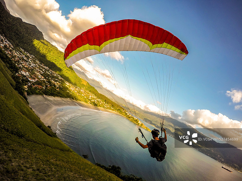 在海滩上空飞行的极限滑翔伞飞行员图片素材