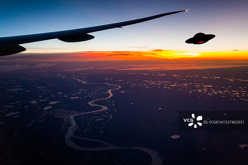 从飞机舷窗看到的飞行UFO图片素材