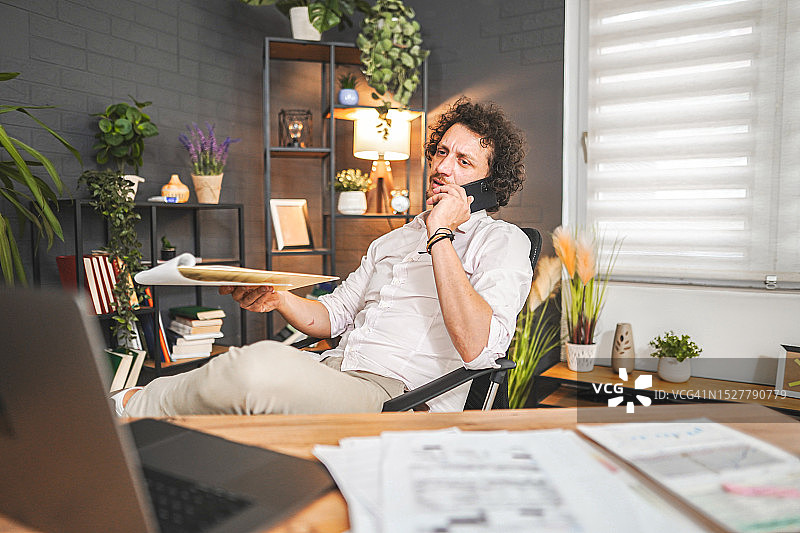 在办公室工作时通过电话交谈的商人图片素材