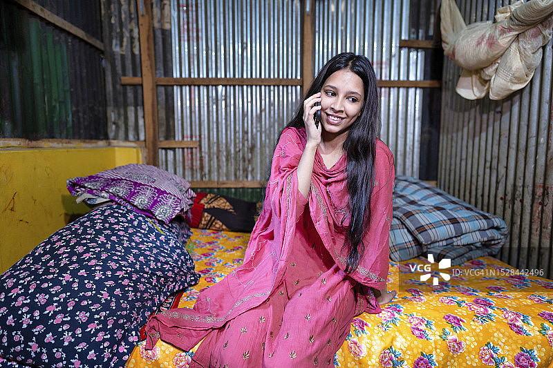 南亚女孩戴头巾，用手机微笑通话图片素材