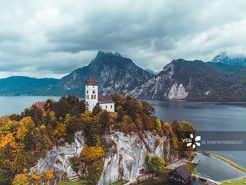 奥地利特劳恩湖上教堂的无人机航拍，背景是秋季的特劳恩施泰因山图片素材