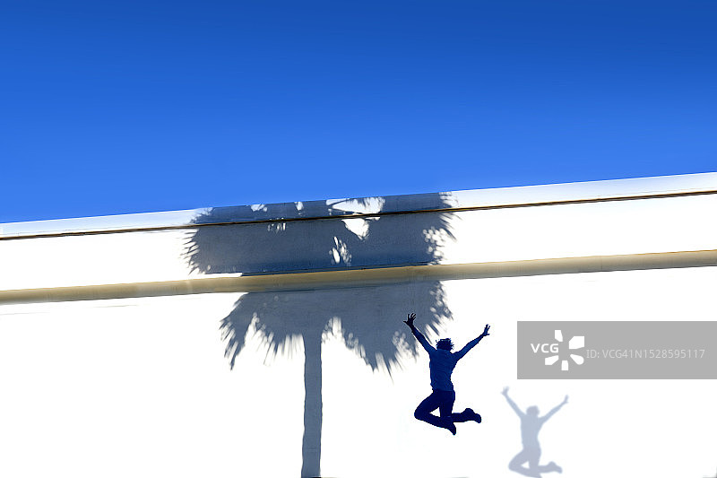 在墙边跳跃的女子图片素材