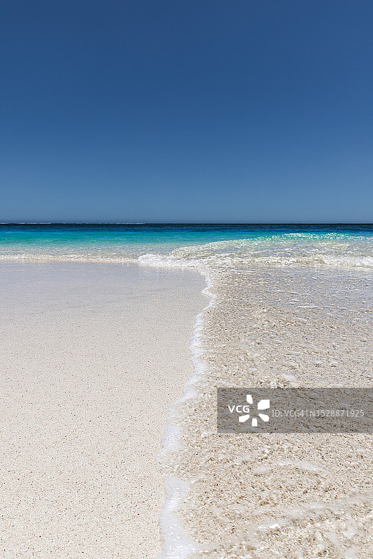 澳大利亚西澳大利亚州埃克斯茅斯绿松石湾的阳光明媚的海滩上，海浪拍打的低角度照片图片素材