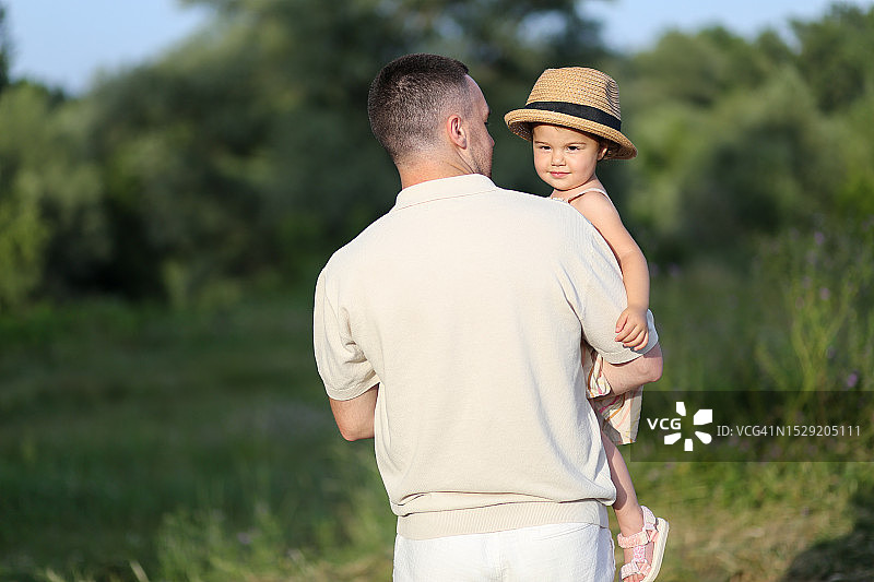 在户外，年轻的父亲抱着小女儿图片素材