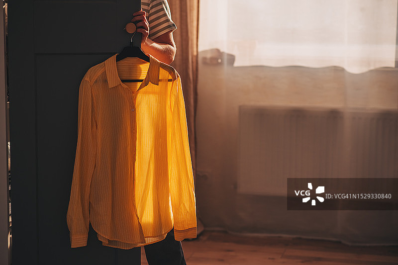 可爱年轻女人站在衣架前挑选衣服图片素材