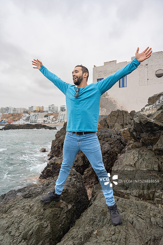 男人在海边山丘举手图片素材