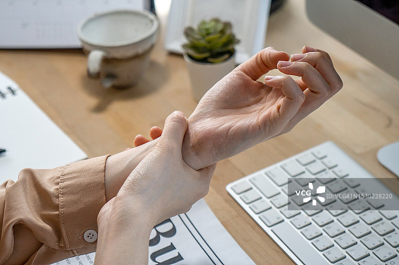 一名手腕疼痛的女人特写图片素材