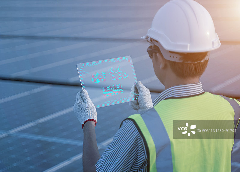 工程师在太阳能发电厂使用显示替代能源的屏幕图片素材