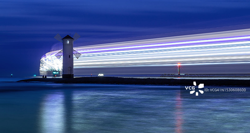 蓝色时刻，灯光照亮离开的渡轮的信标图片素材
