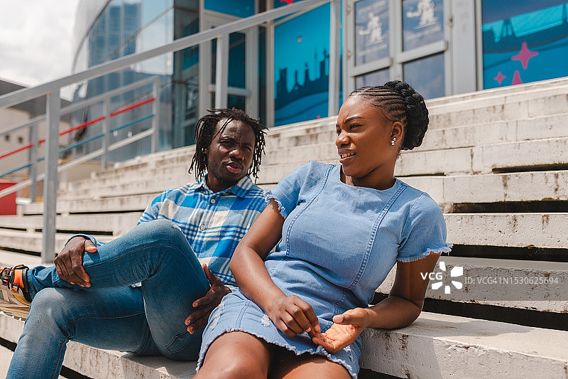 阳光下户外交谈的年轻黑人情侣图片素材