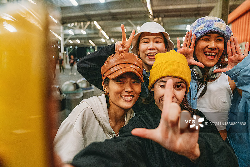 年轻女子穿着时尚的街头服装在晚上自拍图片素材