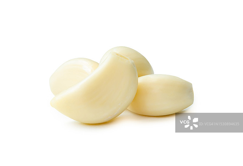 白色背景上堆叠的去皮大蒜瓣，带裁剪路径图片素材