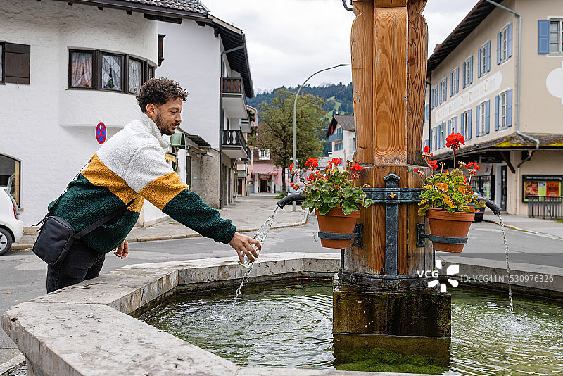 在山泉水龙头处取水图片素材