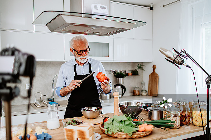 作为美食播主工作的年长男厨师图片素材
