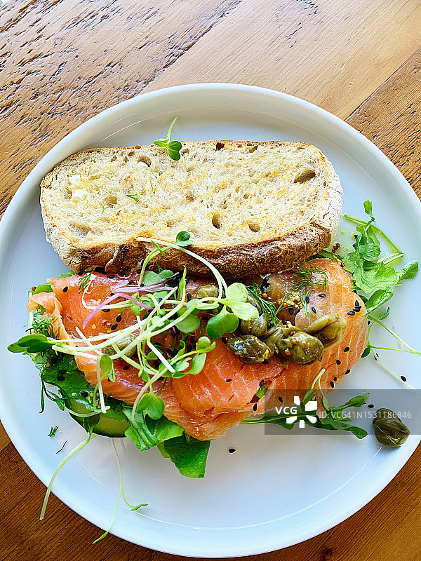 烟熏三文鱼开放式三明治配沙拉和装饰，在酸面包上图片素材