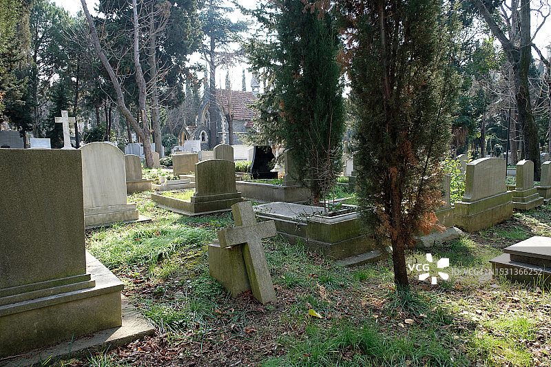 城市公墓：无人看管的旧坟墓，石头墓碑和金属十字架图片素材