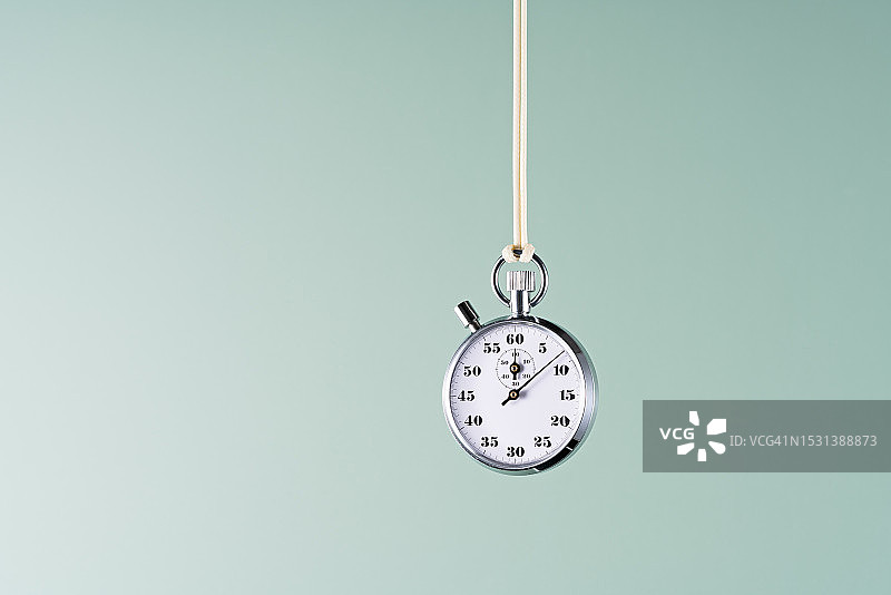 绿色背景上悬挂的白色秒表图片素材