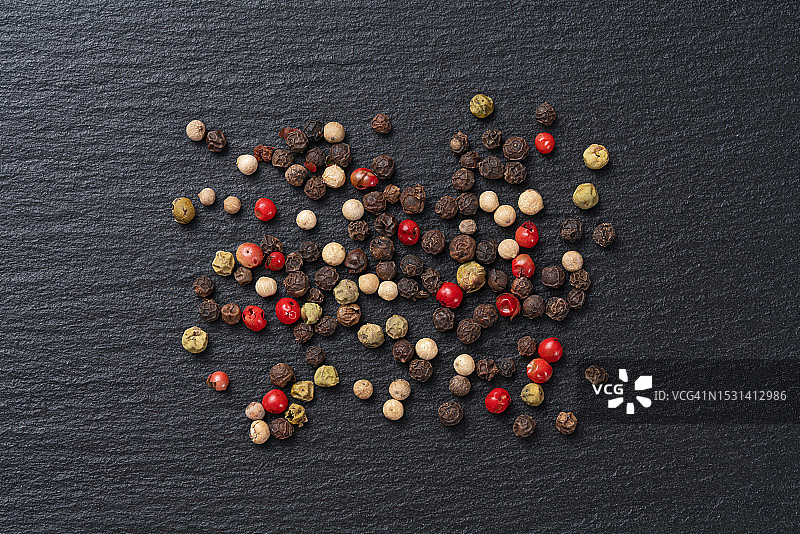 黑色背景上散落的混合胡椒粒图片素材