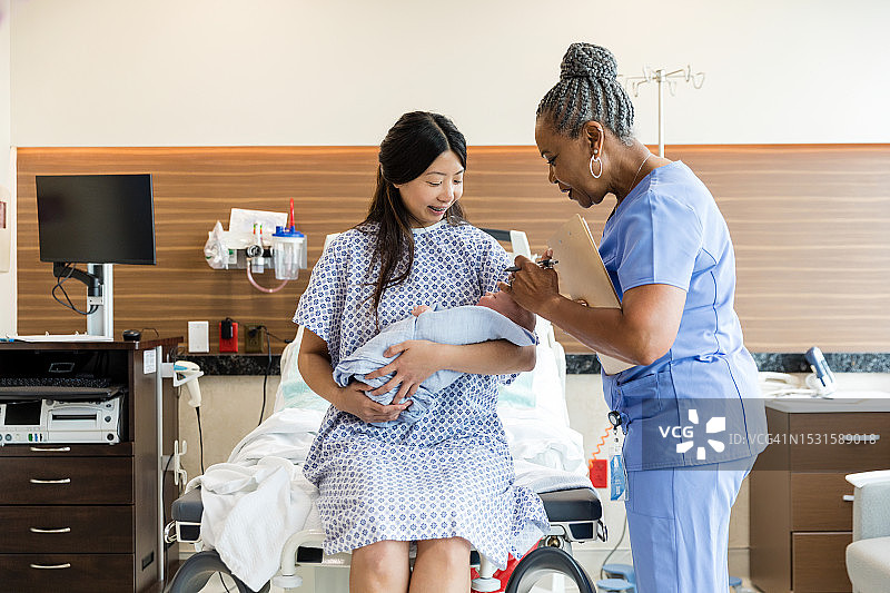 女医生为新生儿完成体检图片素材