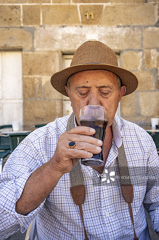 戴帽子的男性游客在露台上休息吃点心图片素材
