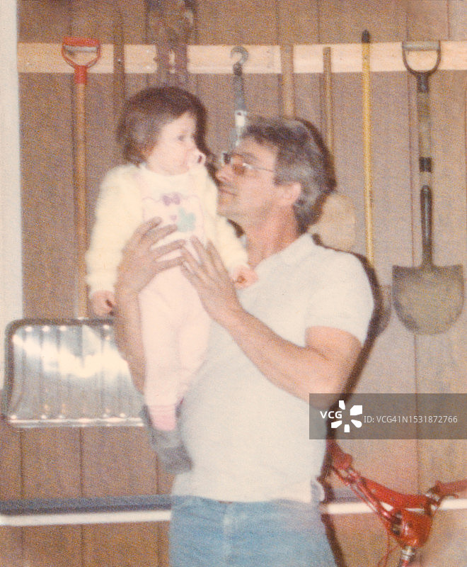 复古父亲抱着女儿（20世纪80年代家庭，1970年代亲情父亲节）图片素材