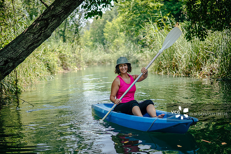 女人在河里划皮划艇，开怀大笑图片素材