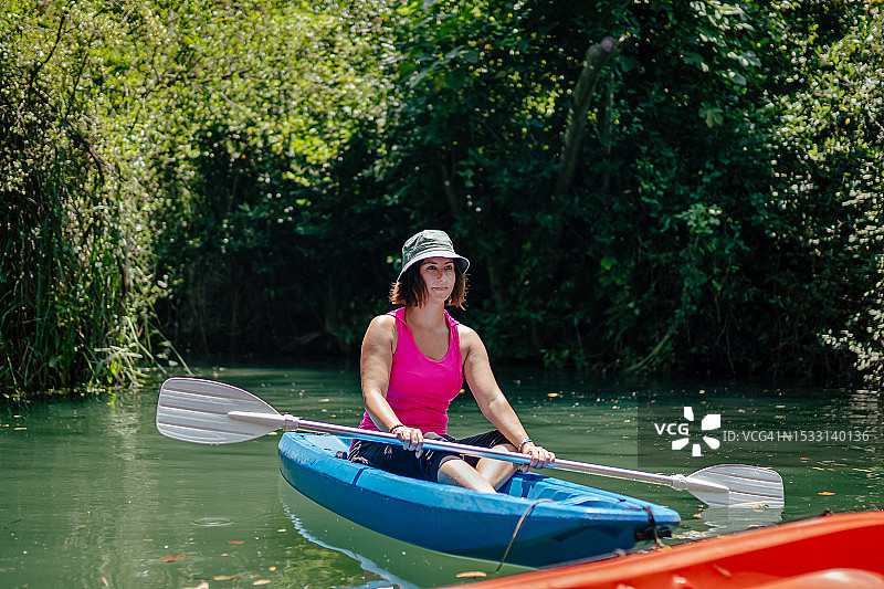 女人在河里划皮划艇，开怀大笑图片素材