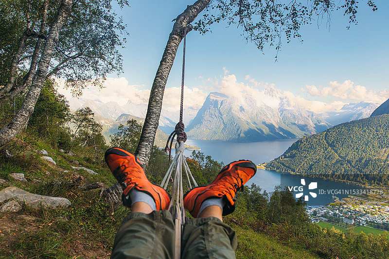 在挪威峡湾欣赏风景的吊床上放松的男子图片素材