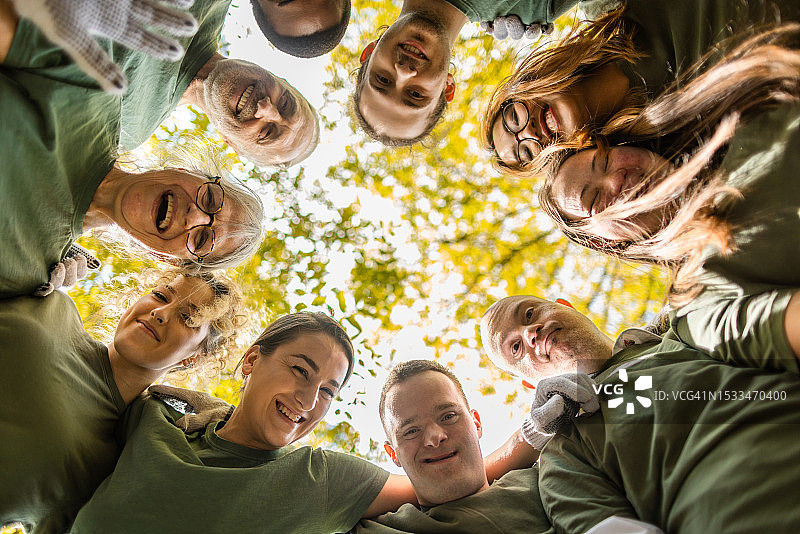 志愿者团体在成功清理森林后拥抱图片素材