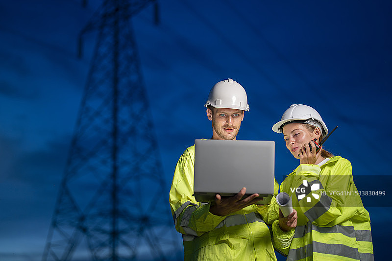 自信的工程师在发电站前使用笔记本电脑图片素材